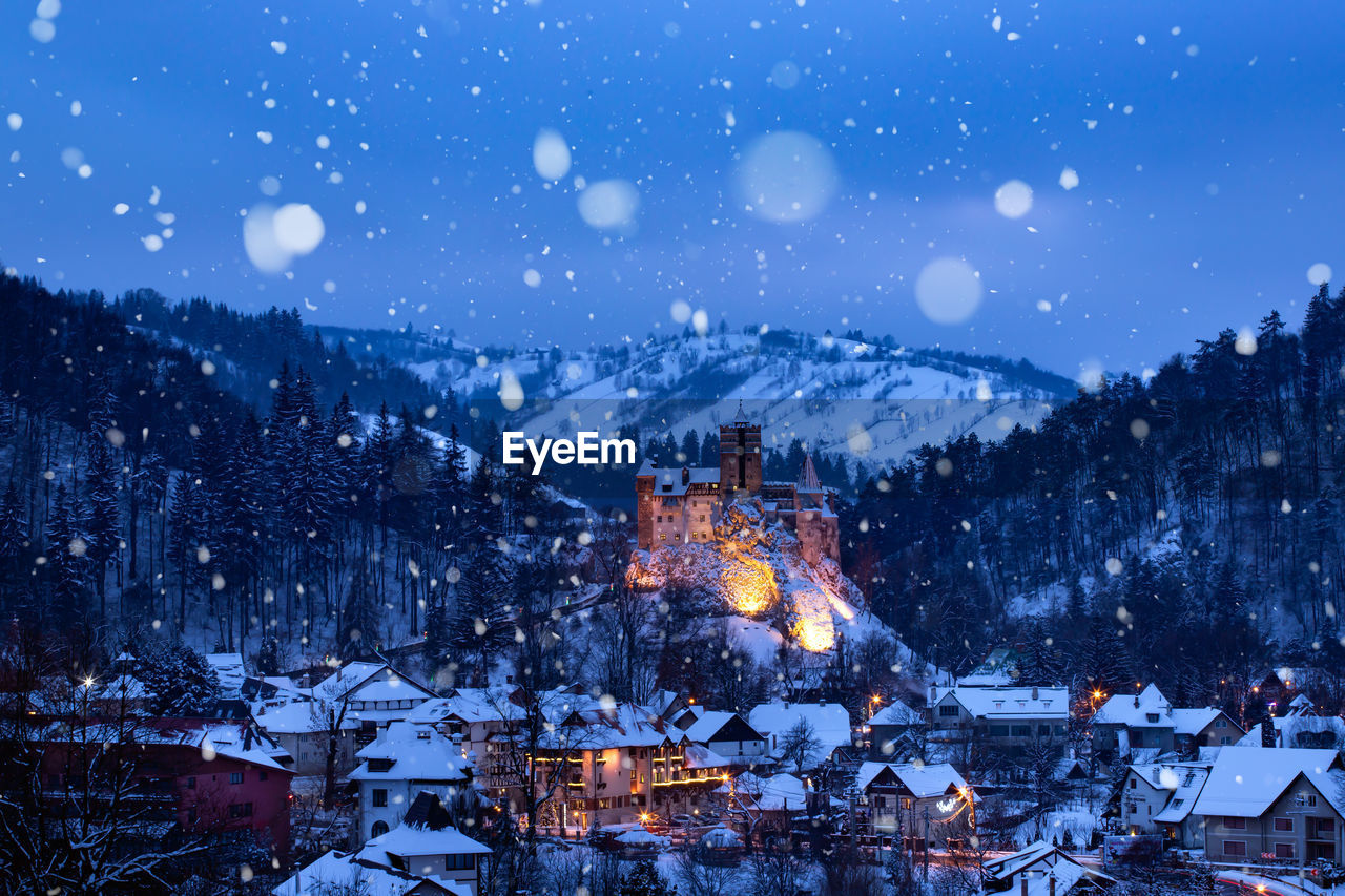 Illuminated buildings in city at night during winter