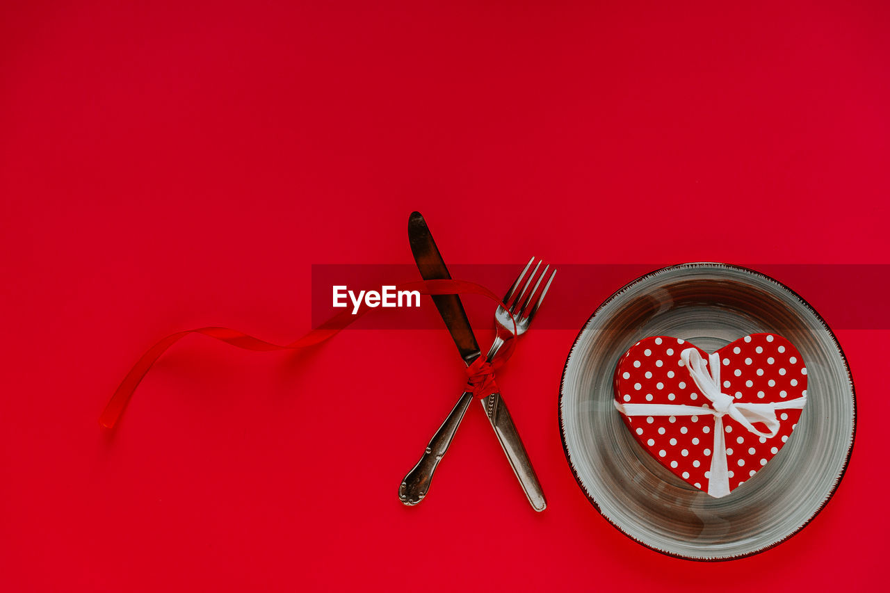 HIGH ANGLE VIEW OF RED WINE ON TABLE AGAINST GRAY BACKGROUND