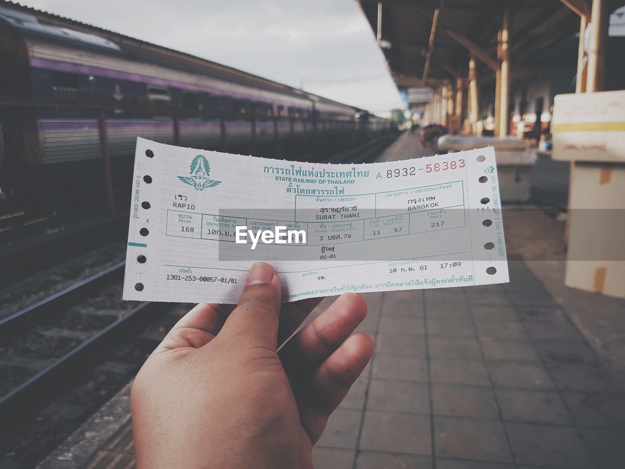 Cropped image of person holding ticket at railroad station