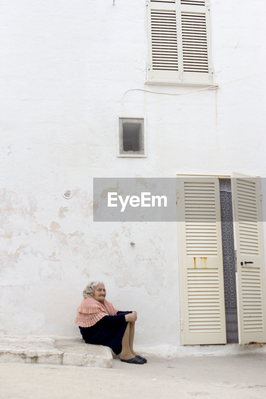 WOMAN STANDING IN FRONT OF BUILDING