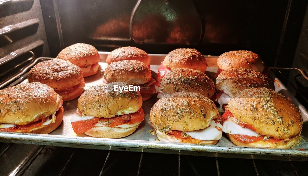 Burgers arranged on baking sheet