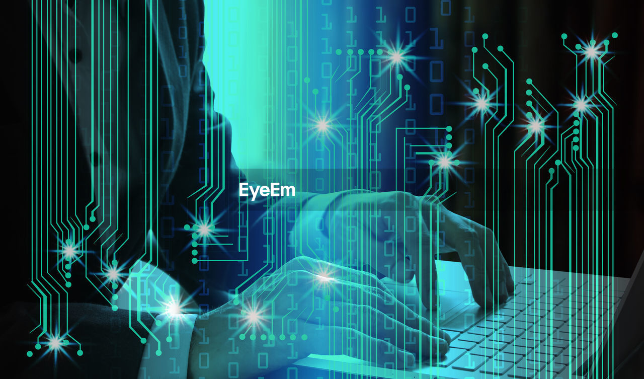 Digital composite image of businessman using laptop with binary codes