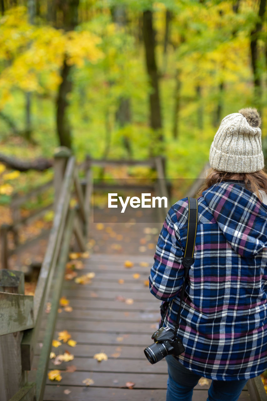 Rear view of woman hiking on trail in autumn in porcupine mountains state park, michigan