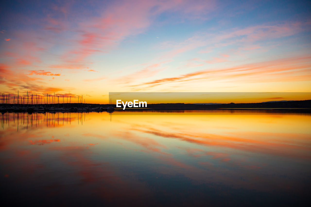 SCENIC VIEW OF LAKE AGAINST SKY DURING SUNSET