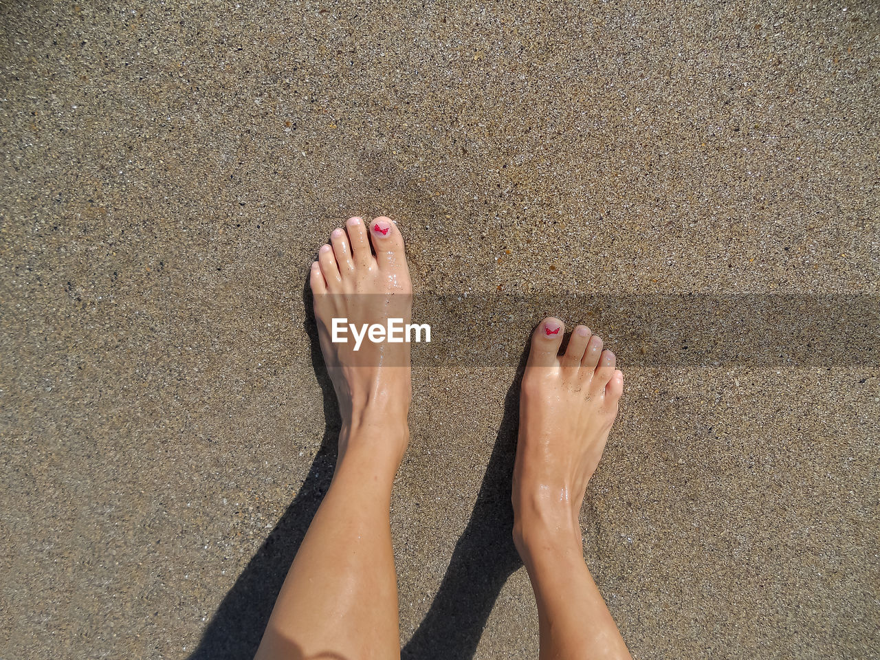 LOW SECTION OF WOMAN ON SAND