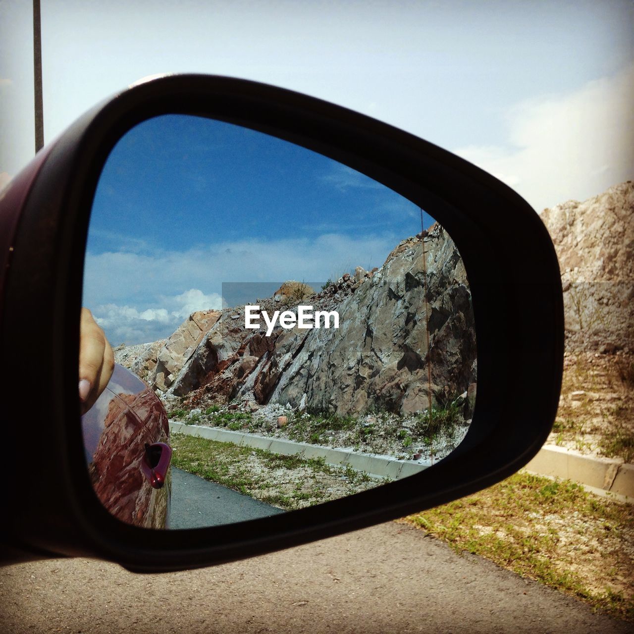 Reflection of rock formation on side-view mirror