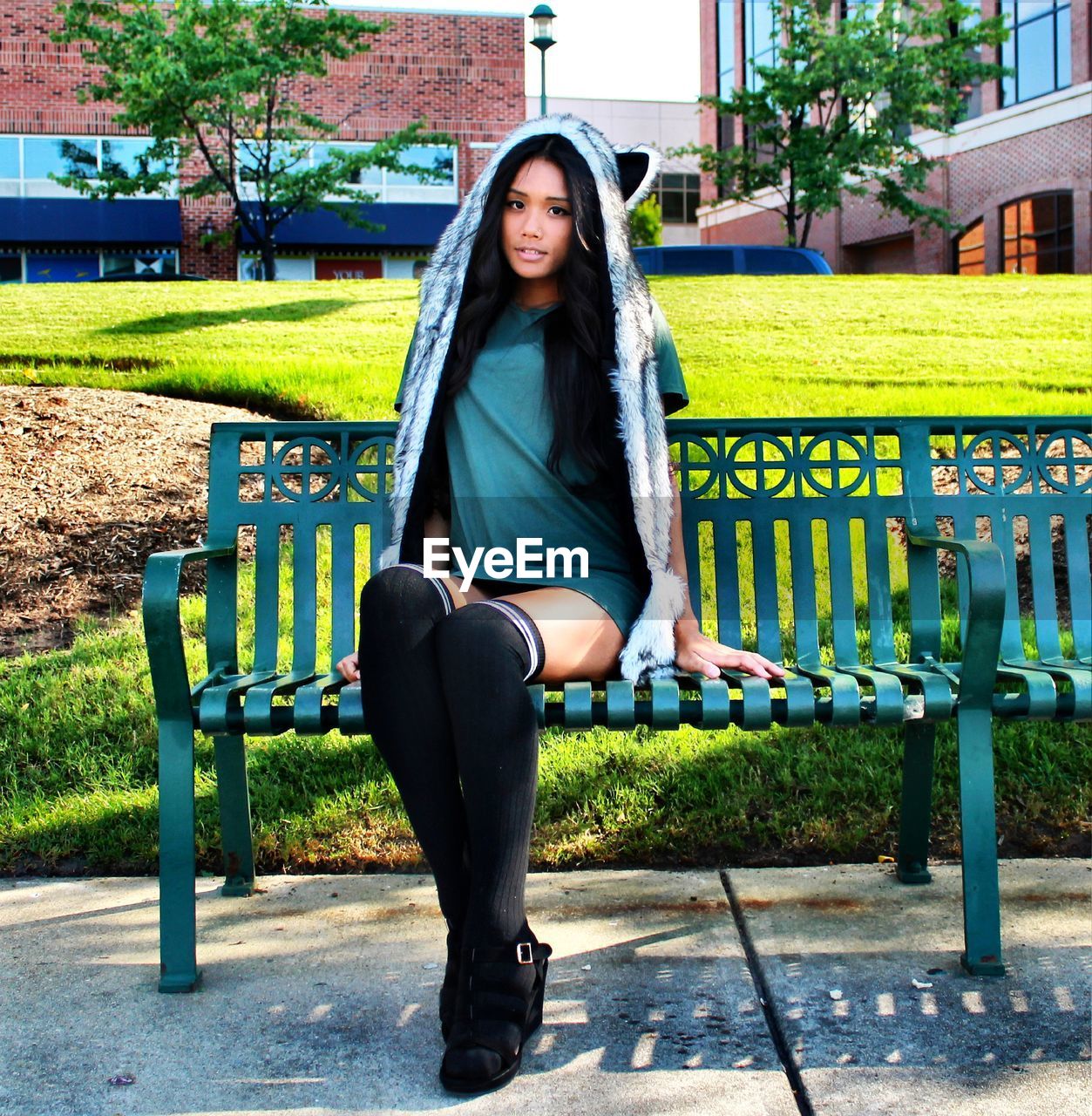 PORTRAIT OF BEAUTIFUL WOMAN SITTING ON TREE