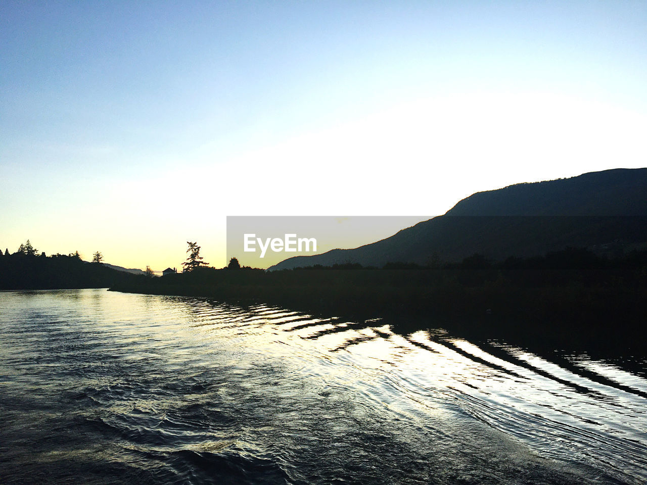 SCENIC VIEW OF SILHOUETTE MOUNTAINS AGAINST CLEAR SKY AT SUNSET