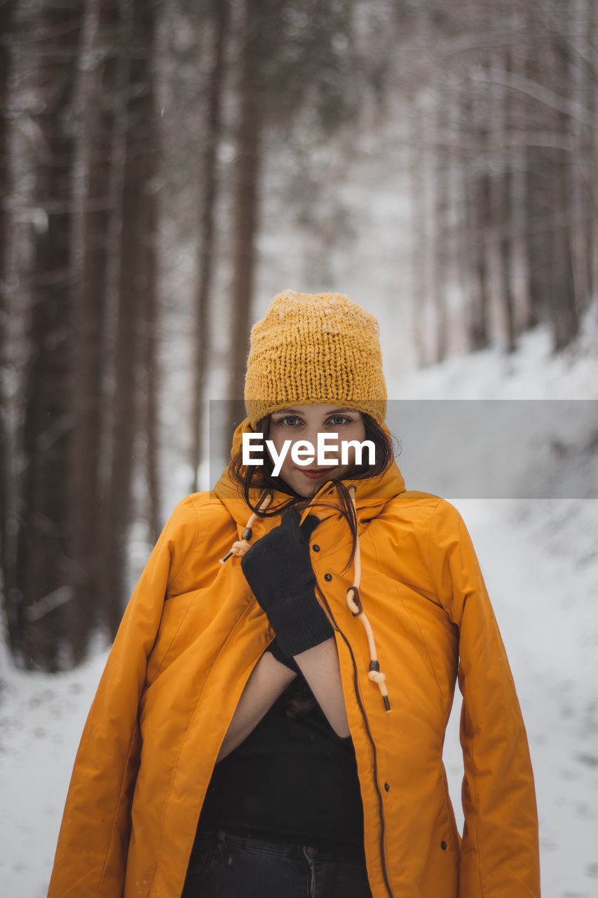 Young woman wearing hat standing on snow covered land