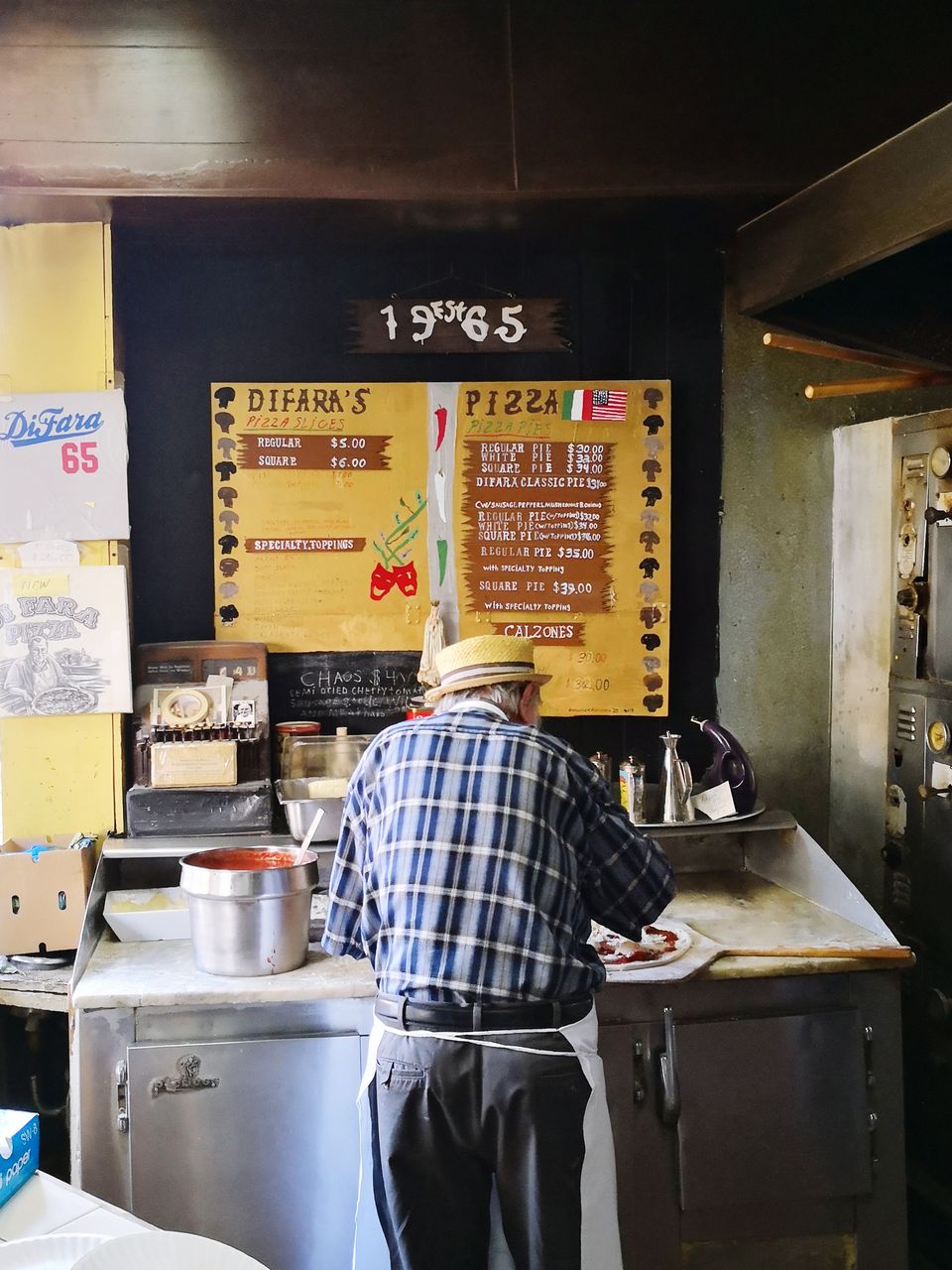 REAR VIEW OF MAN STANDING AT RESTAURANT