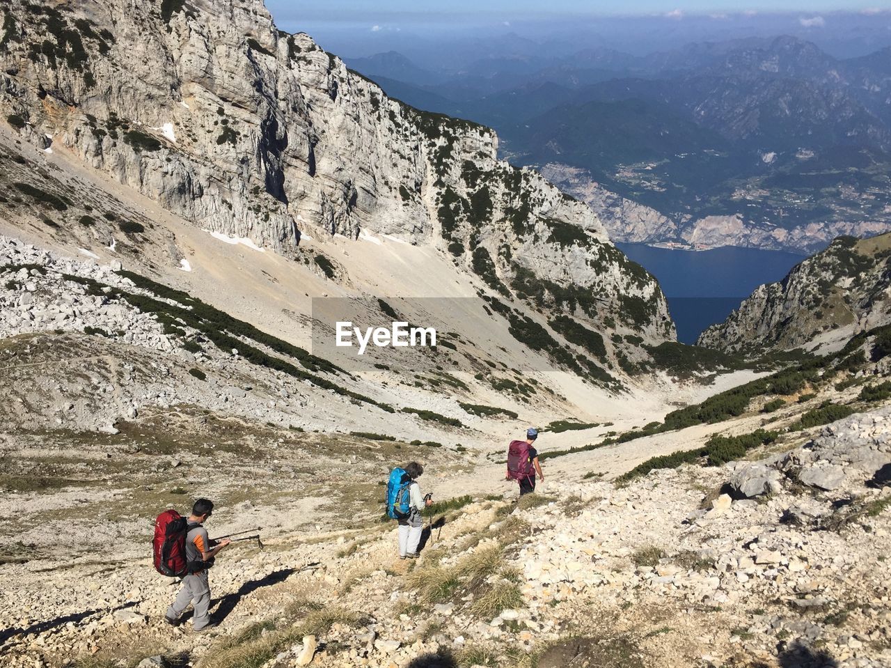 PEOPLE WALKING ON MOUNTAIN AGAINST MOUNTAINS