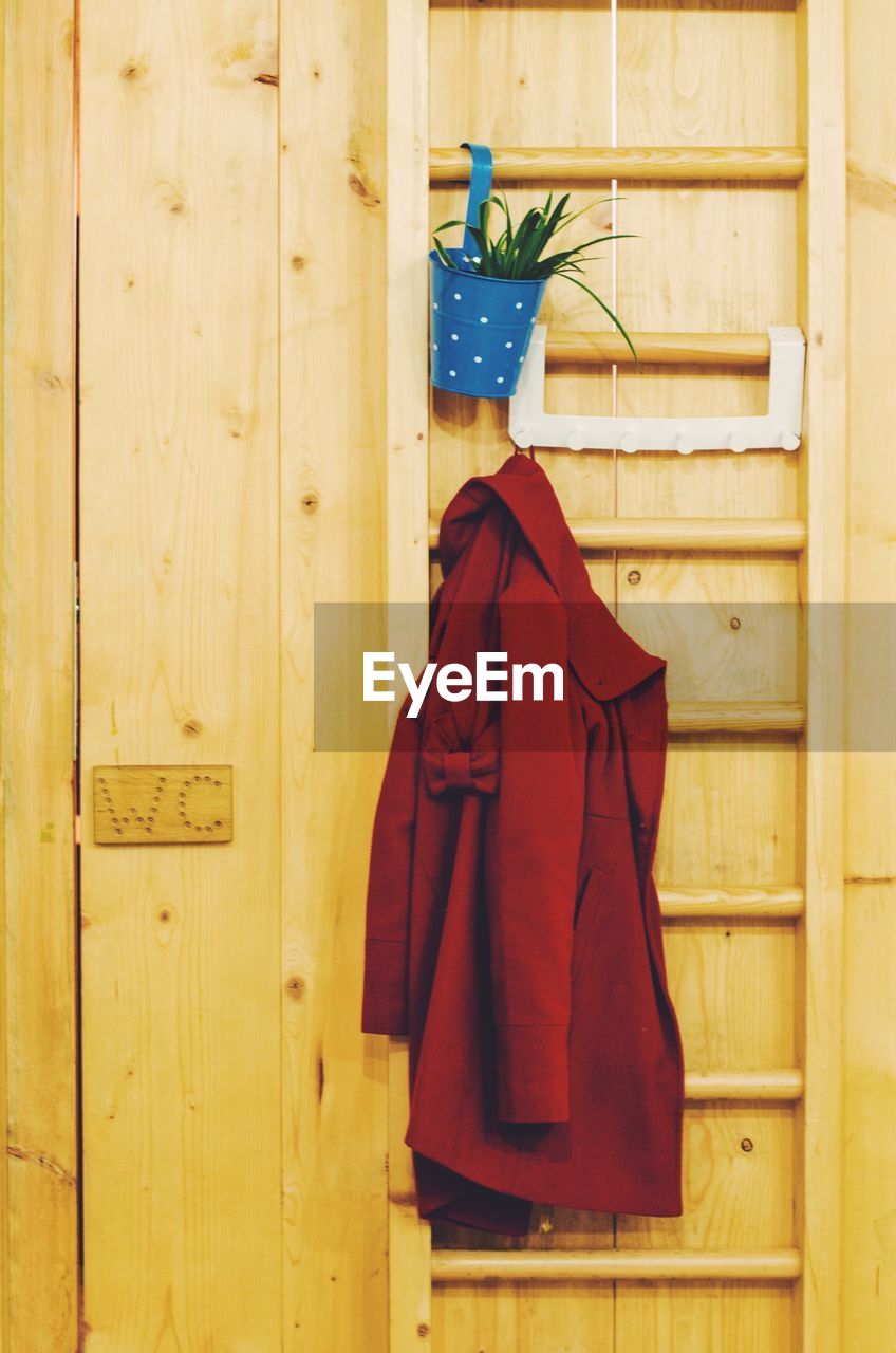 Close-up of red jacket on ladder against restroom sign