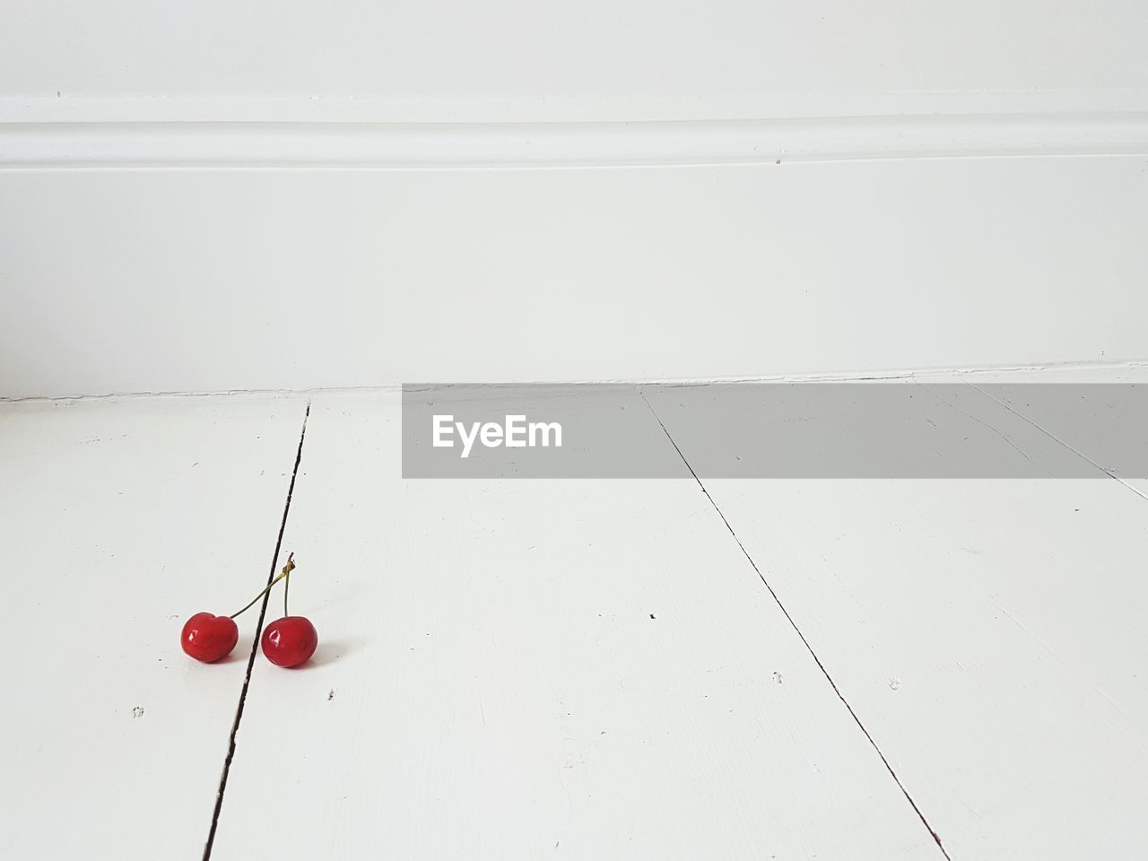 High angle view of cherries on white floor against wall