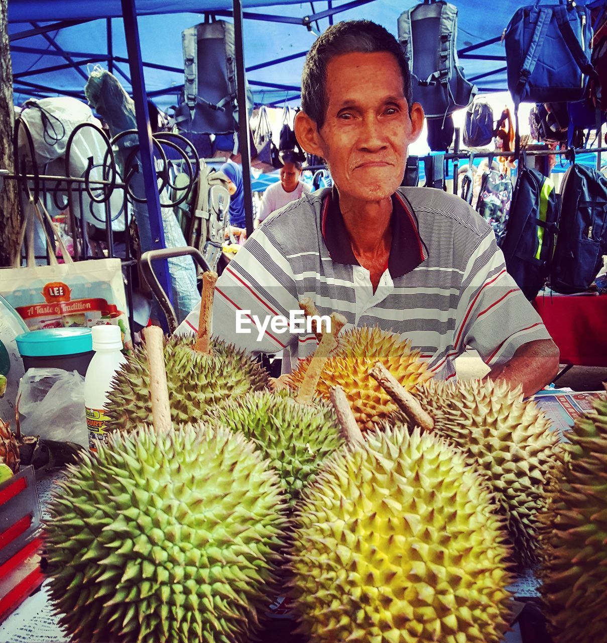 PORTRAIT OF SMILING YOUNG WOMAN IN MARKET