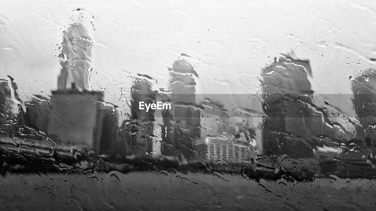 CLOSE-UP OF WET GLASS WINDOW IN CITY