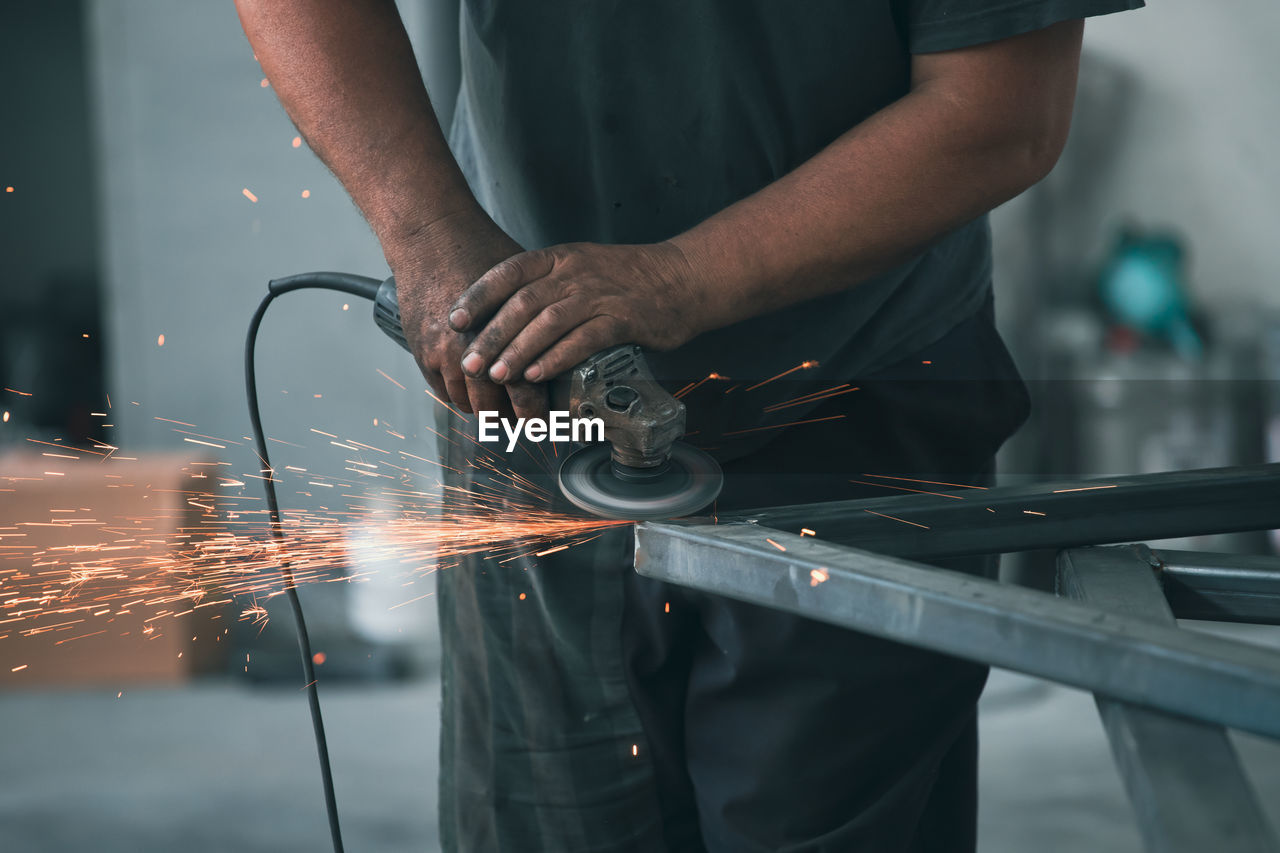 midsection of man working at workshop