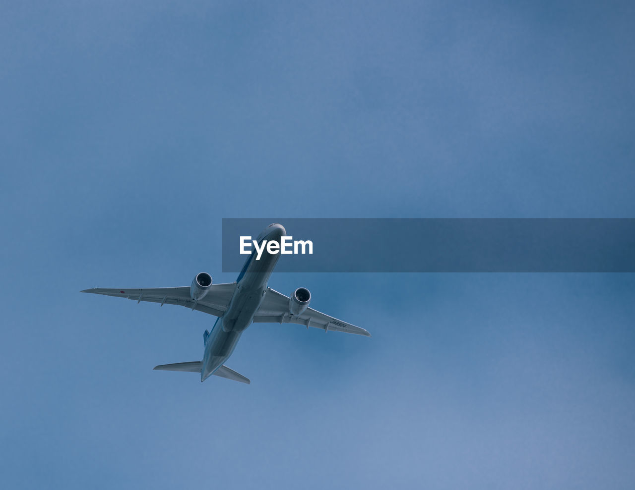 Low angle view of airplane flying in cloudy sky