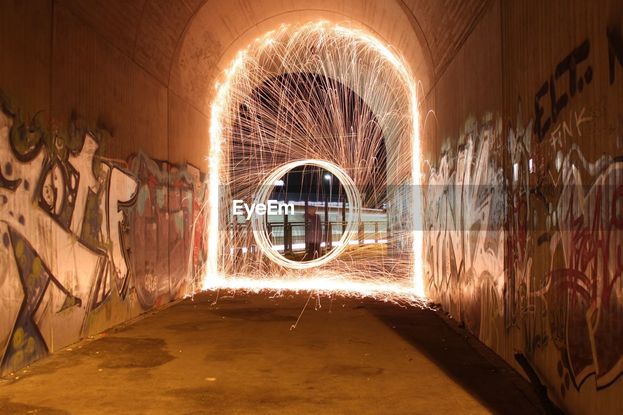 Man spinning wire wool in tunnel at night