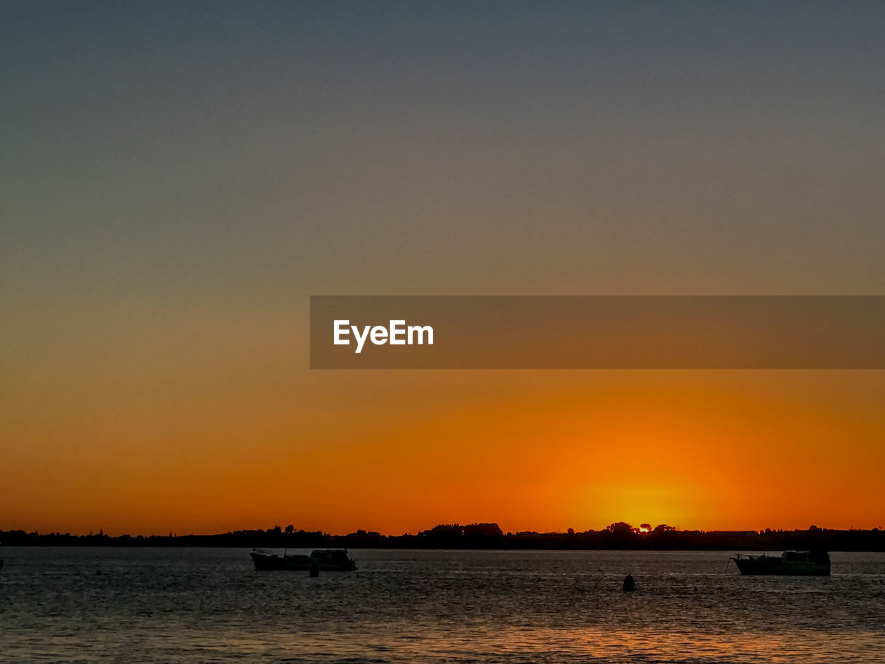 SCENIC VIEW OF SEA AGAINST ORANGE SKY DURING SUNSET