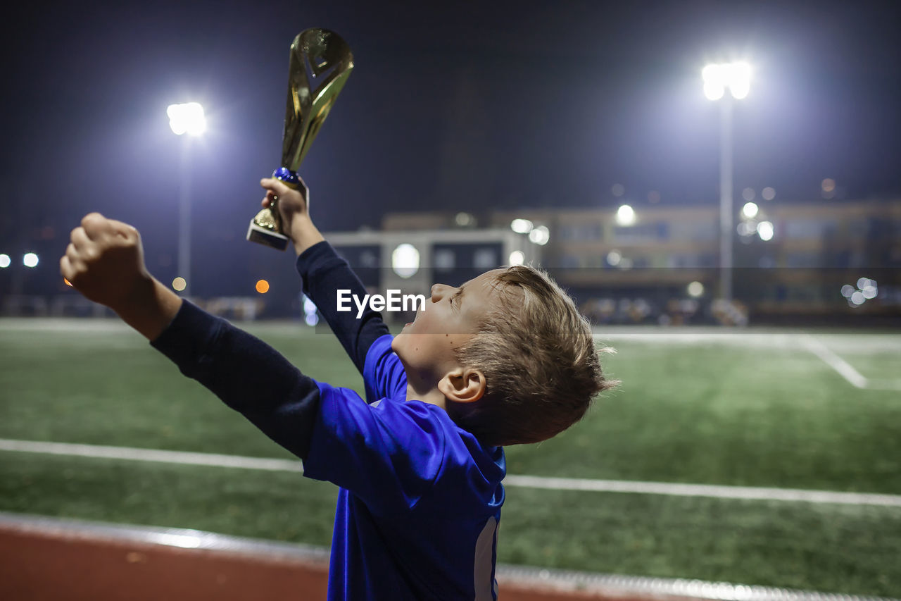 Cute boy holding trophy