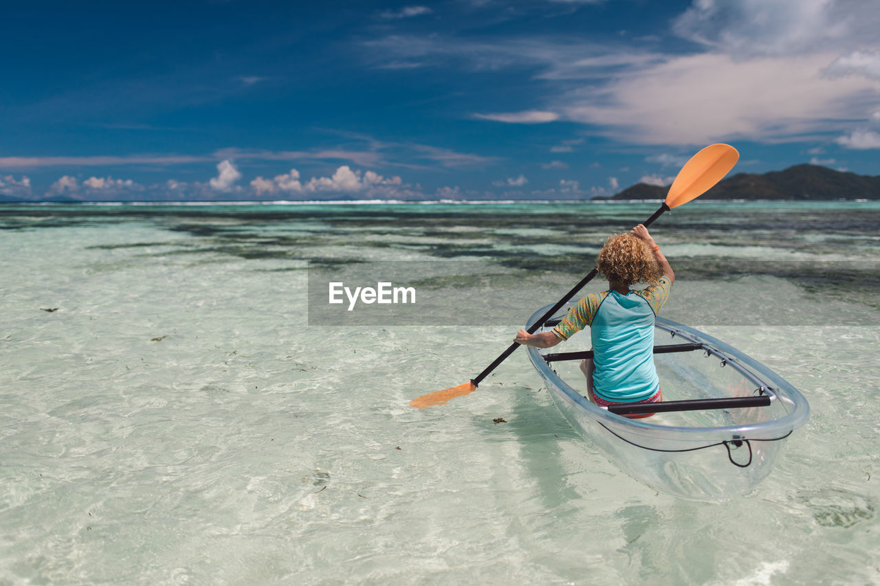 Rear view of woman boating in sea