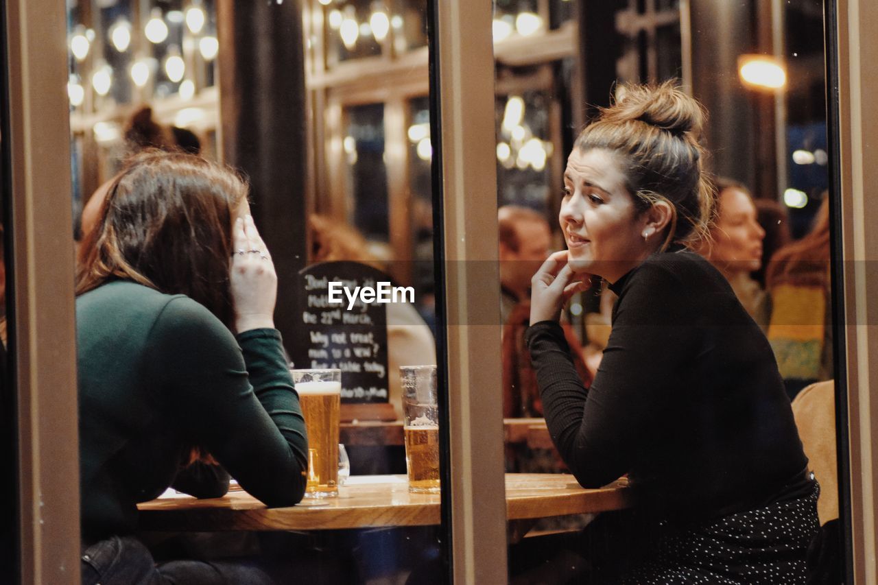 WOMAN SITTING AT RESTAURANT