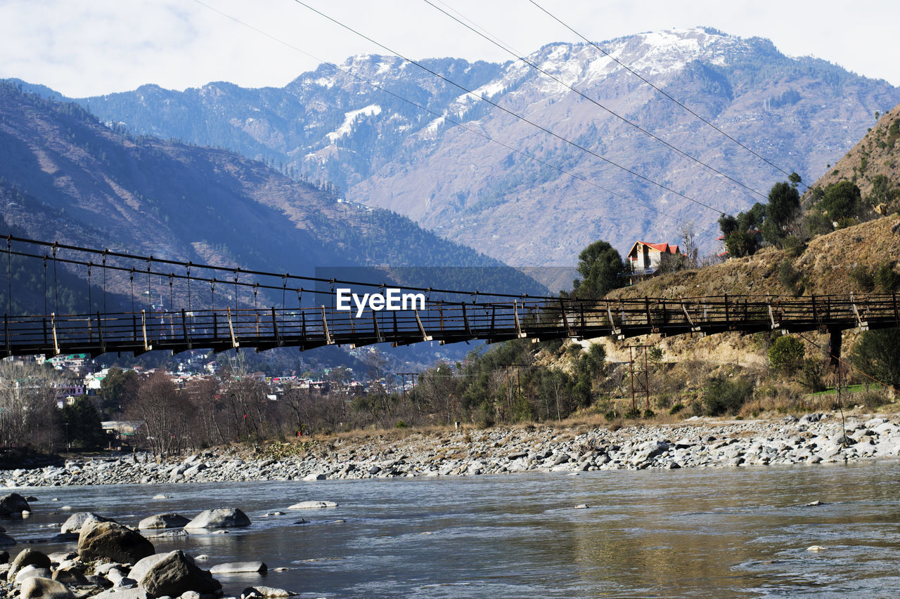 Bridge over river against mountains