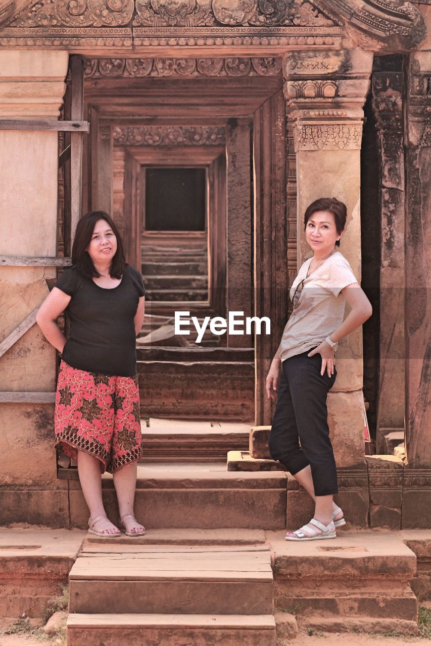 Full length of smiling women standing at entrance