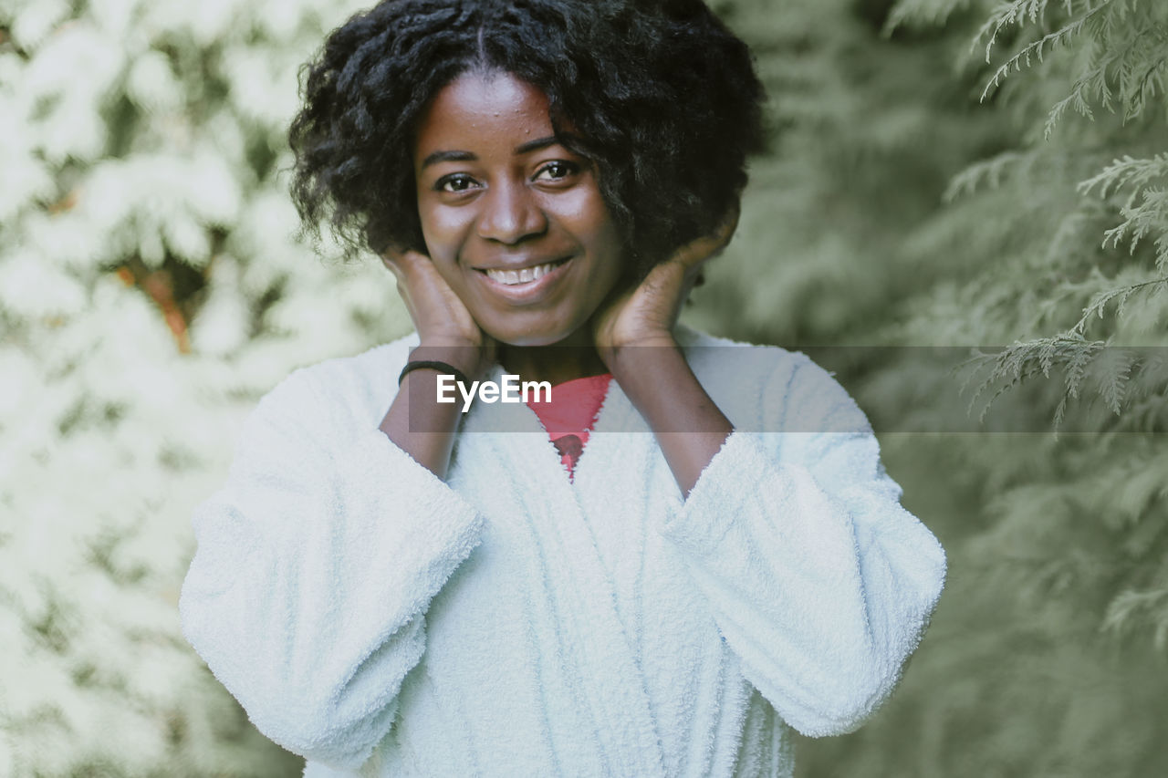 Portrait of smiling young woman standing in park