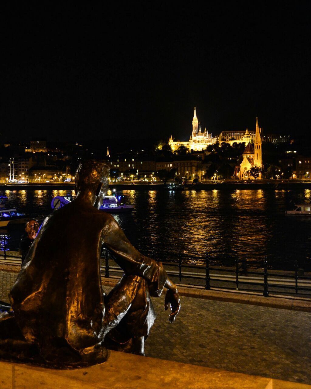 VIEW OF ILLUMINATED CITY AT RIVERBANK