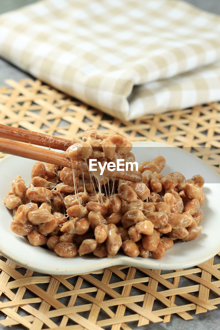 Close up natto fermented soybean with stinky smell. japanese healthy traditional food. lift natto