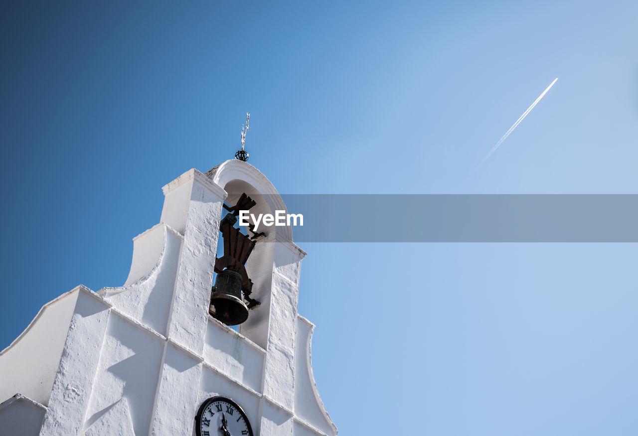 Low angle view of bell tower against blue sky