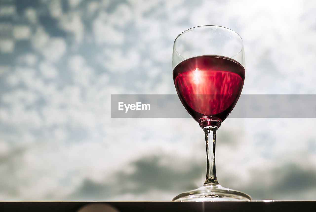 Low angle view of wineglass against sky