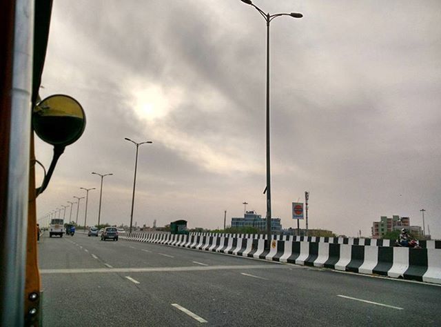 ROAD PASSING THROUGH HIGHWAY AGAINST CLOUDY SKY