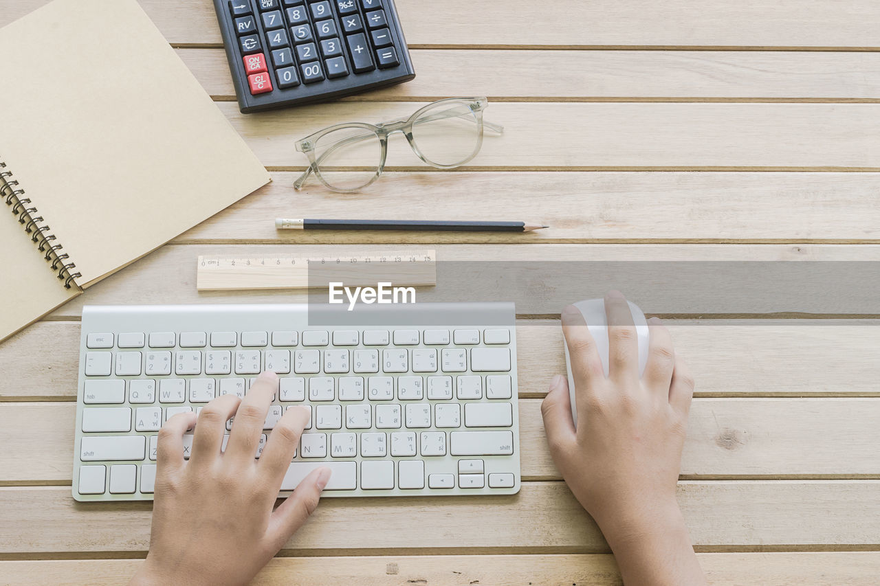 Cropped hands using wireless keyboard on table