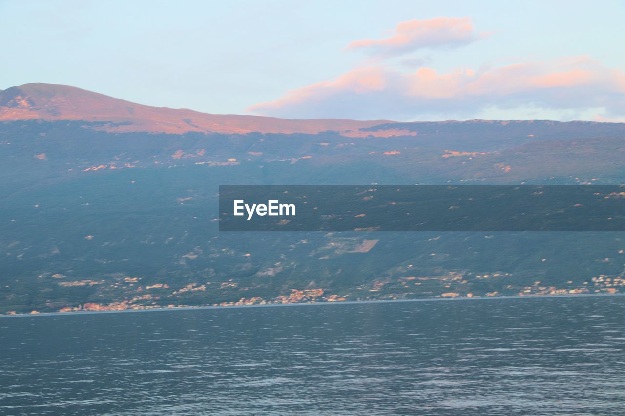 SCENIC VIEW OF SEA BY MOUNTAINS AGAINST SKY