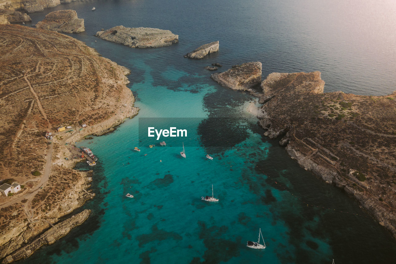 HIGH ANGLE VIEW OF ROCKS ON SEA