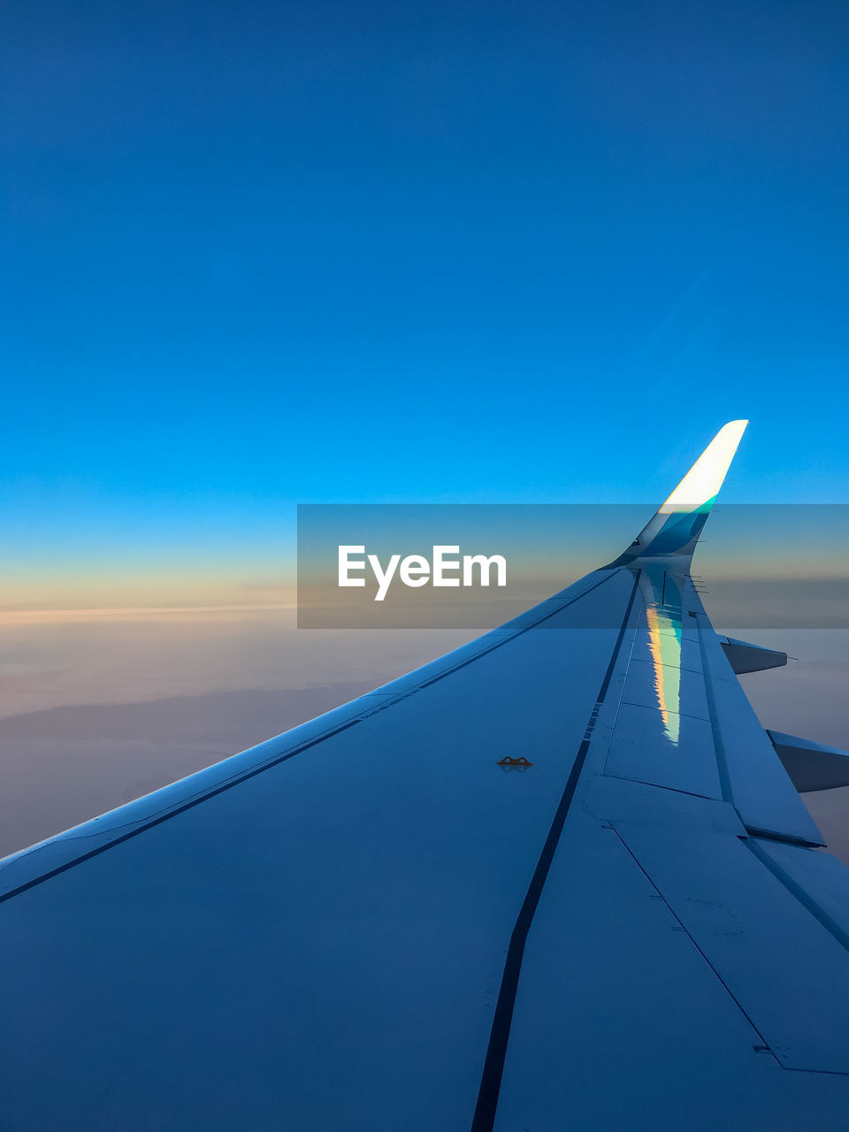 AIRPLANE WING AGAINST CLEAR BLUE SKY