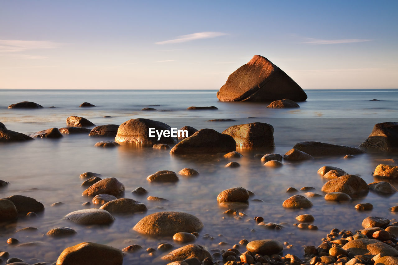 Surface level view of calm pebble beach at sunrise