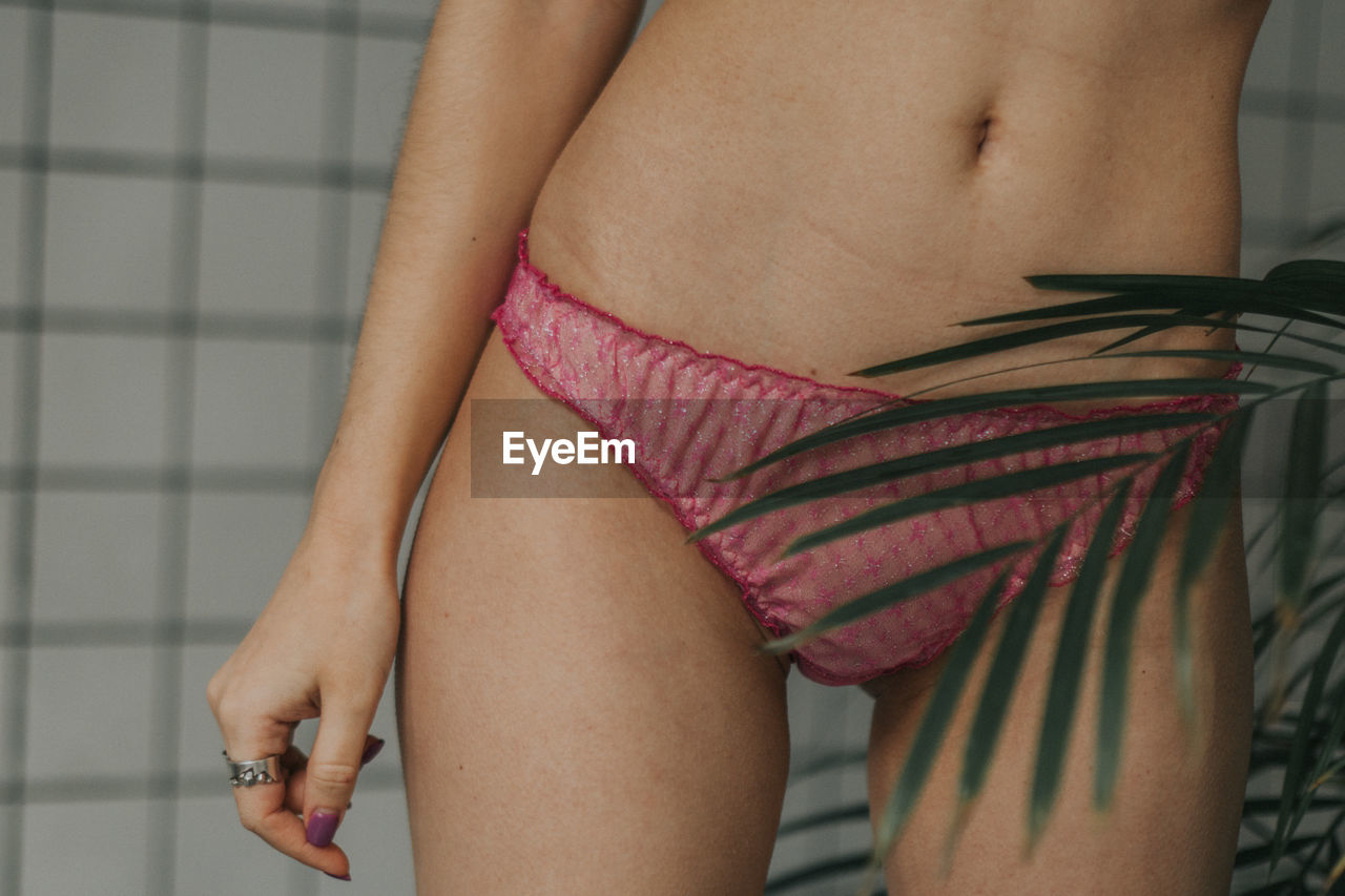 Girl in pink underwear, tropical leaf and white backgroun