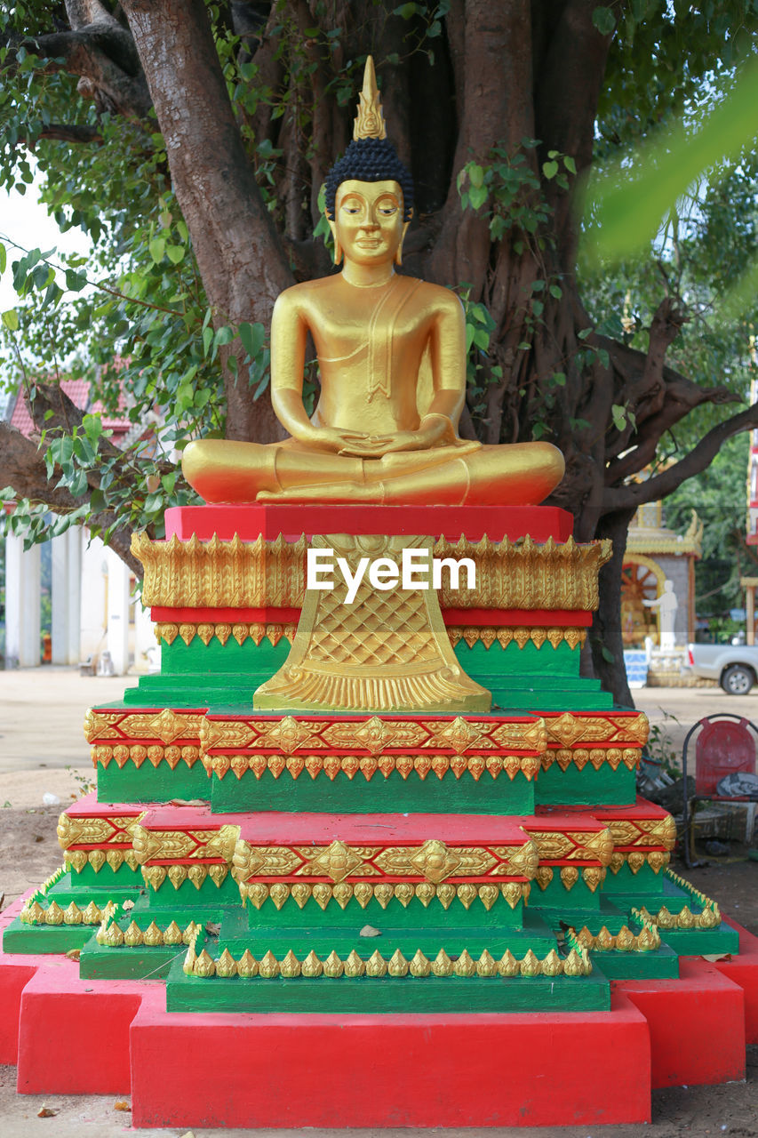 STATUE OF BUDDHA AGAINST BUILDING