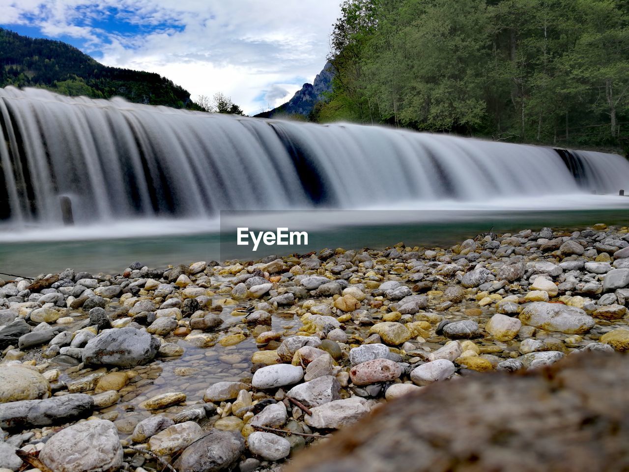 SCENIC VIEW OF WATERFALL AGAINST TREES