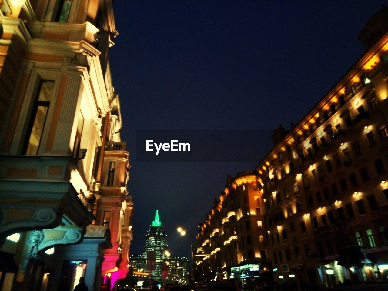 LOW ANGLE VIEW OF ILLUMINATED CITY AGAINST CLEAR SKY