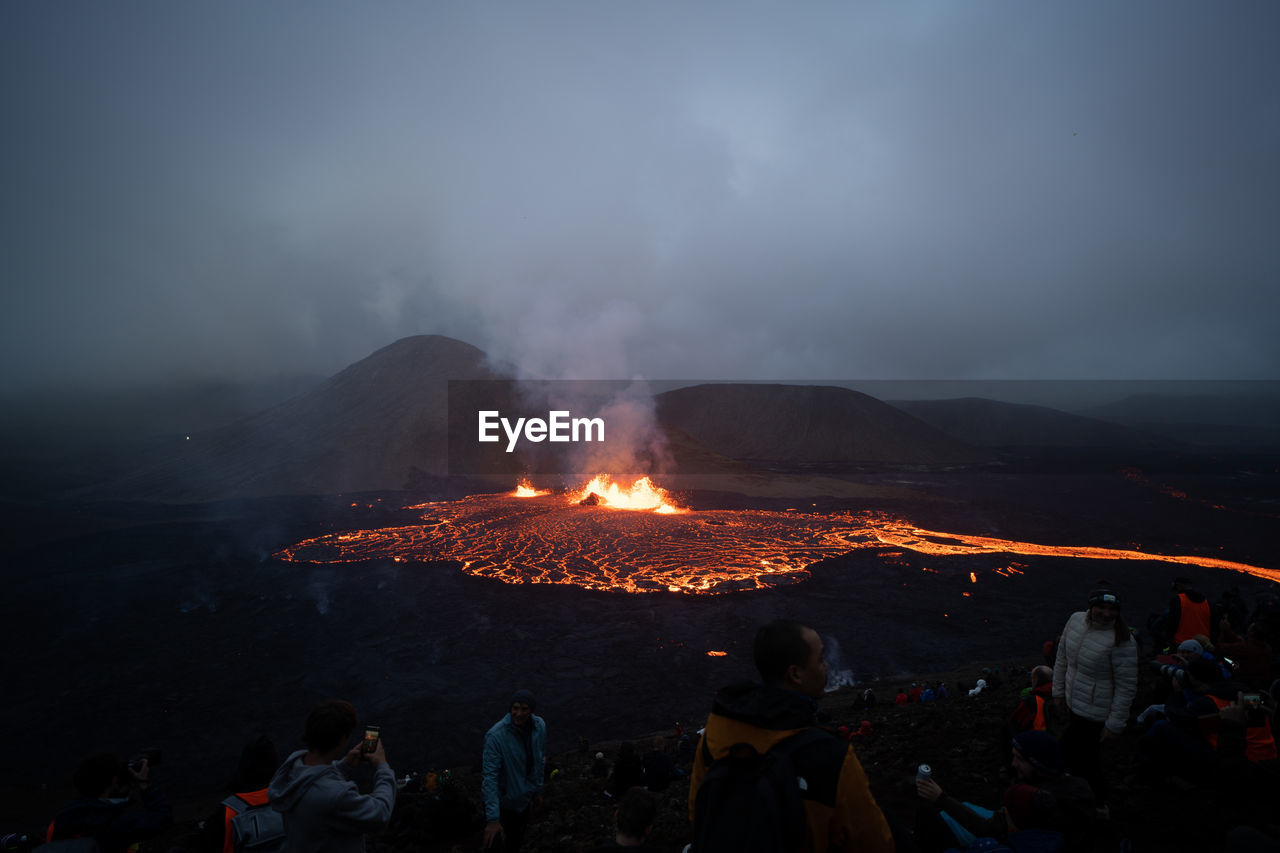 Hikers watching meradalir eruption of fagradalsfjall volcano in iceland 2022