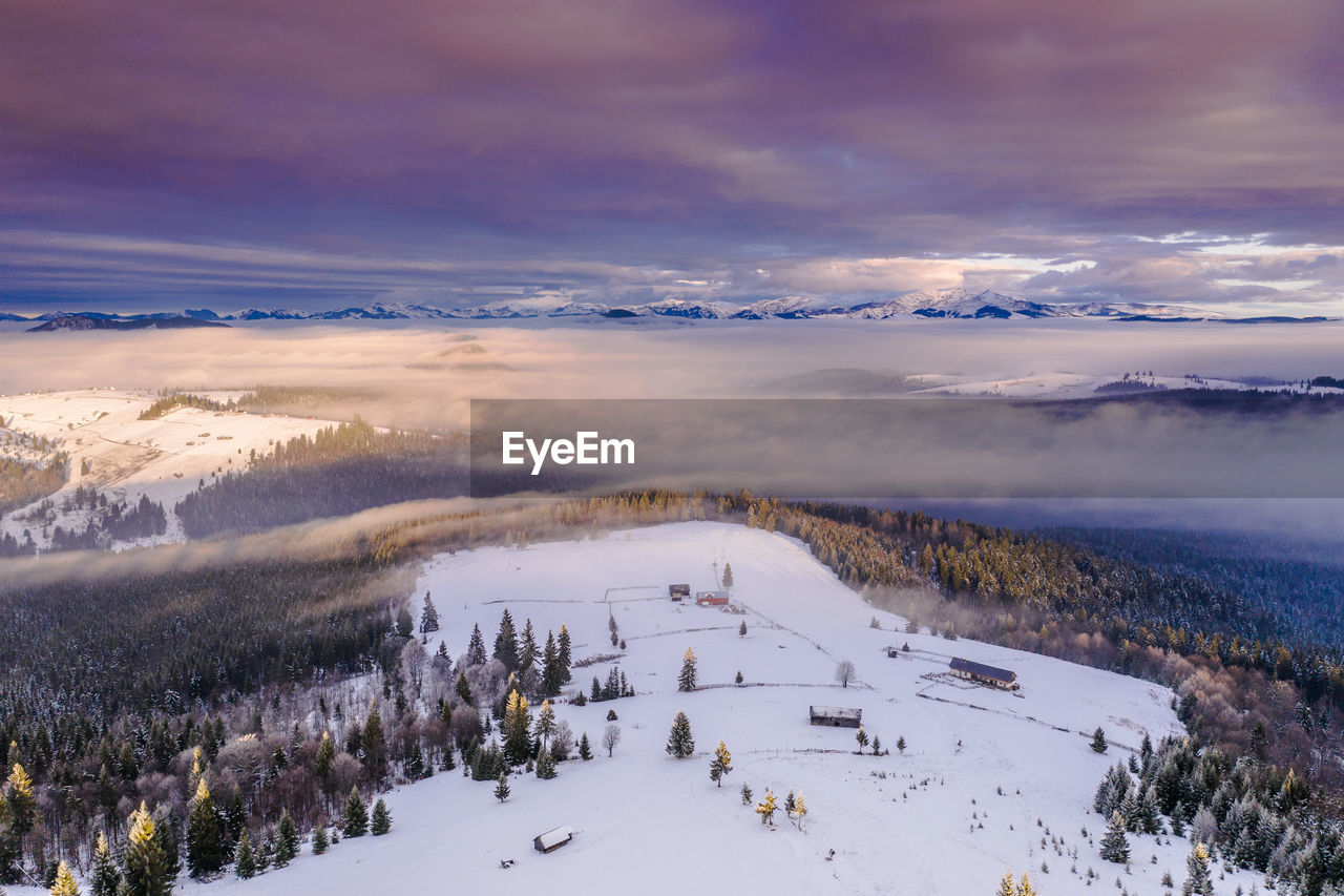 Scenic view of snow covered landscape against sky during sunset