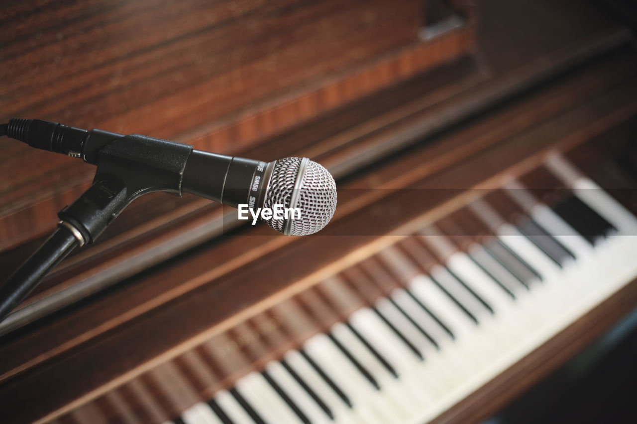 Detail shot of microphone against piano keys