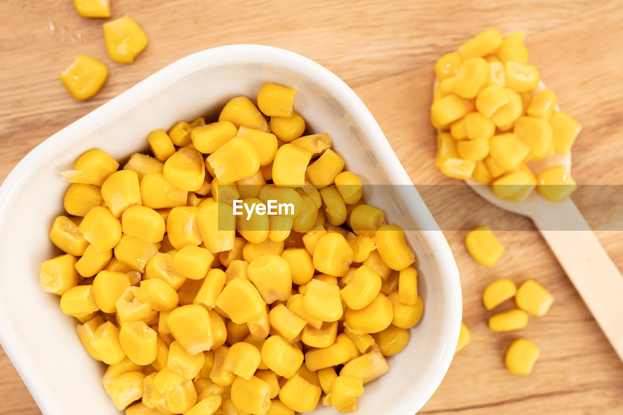 Sweet corn kernels in bowl on wooden table still life