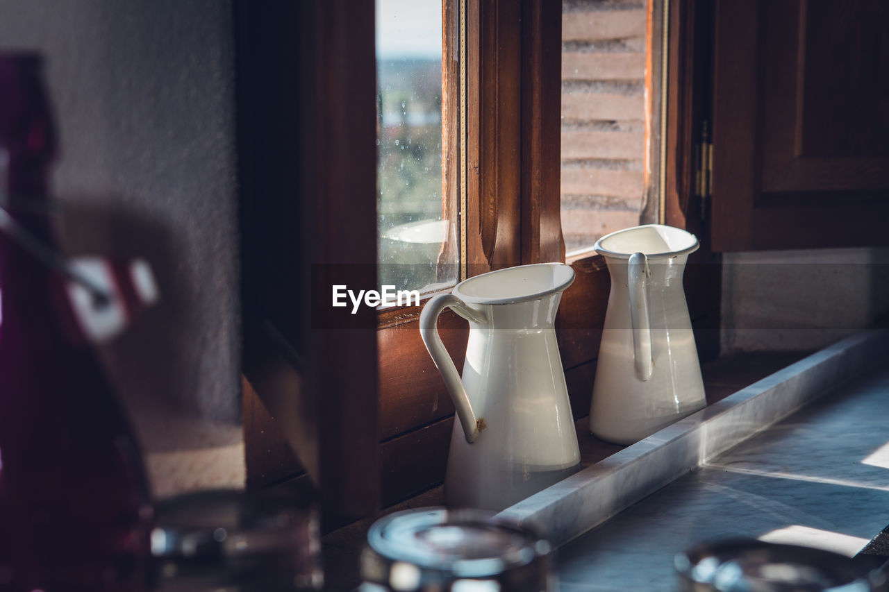 High angle view of jugs by window at home