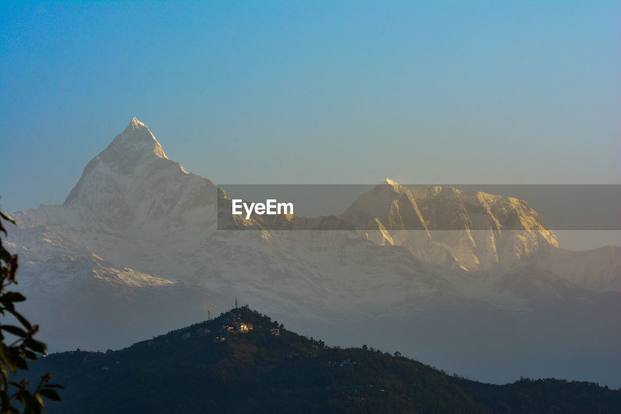 Scenic view of snowcapped mountains against clear sky