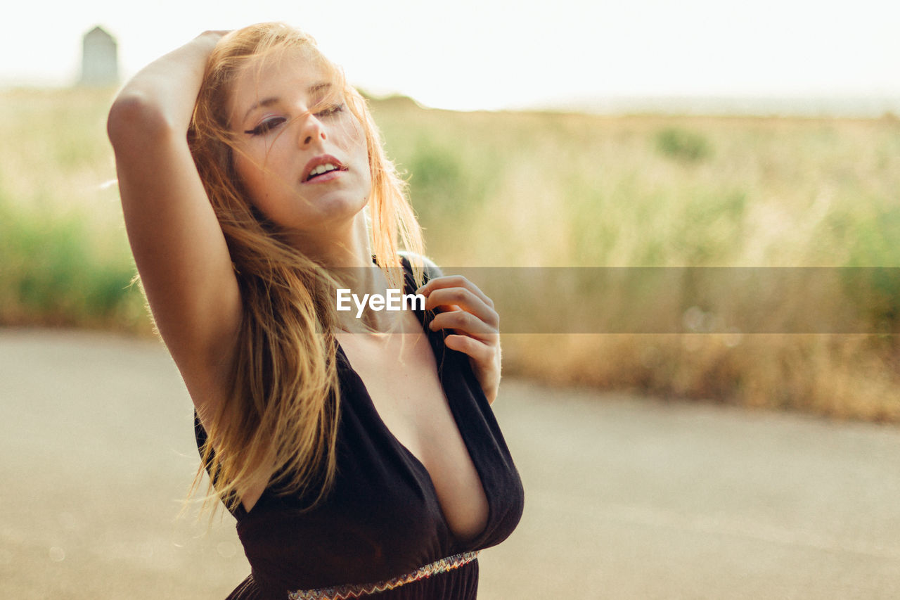 PORTRAIT OF BEAUTIFUL YOUNG WOMAN WITH ROAD